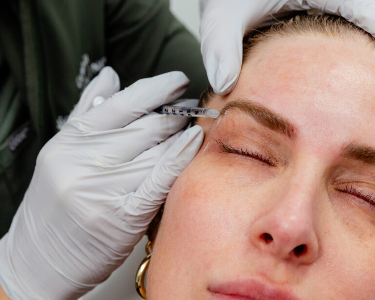 Needle inserted underneath woman's eyebrow