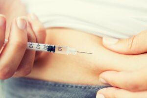 A close-up of a patient injecting GLP-1 in Denville