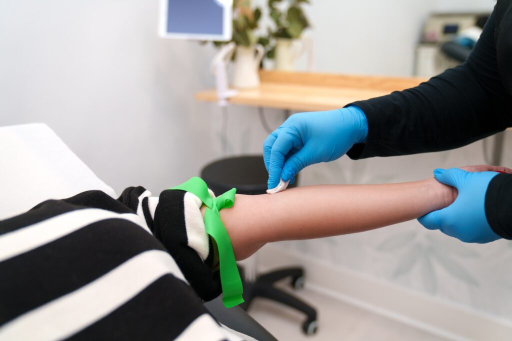 Image of a provider at Exhibit Medical Aesthetics preparing a patient to receive IV vitamin therapy in Denville.